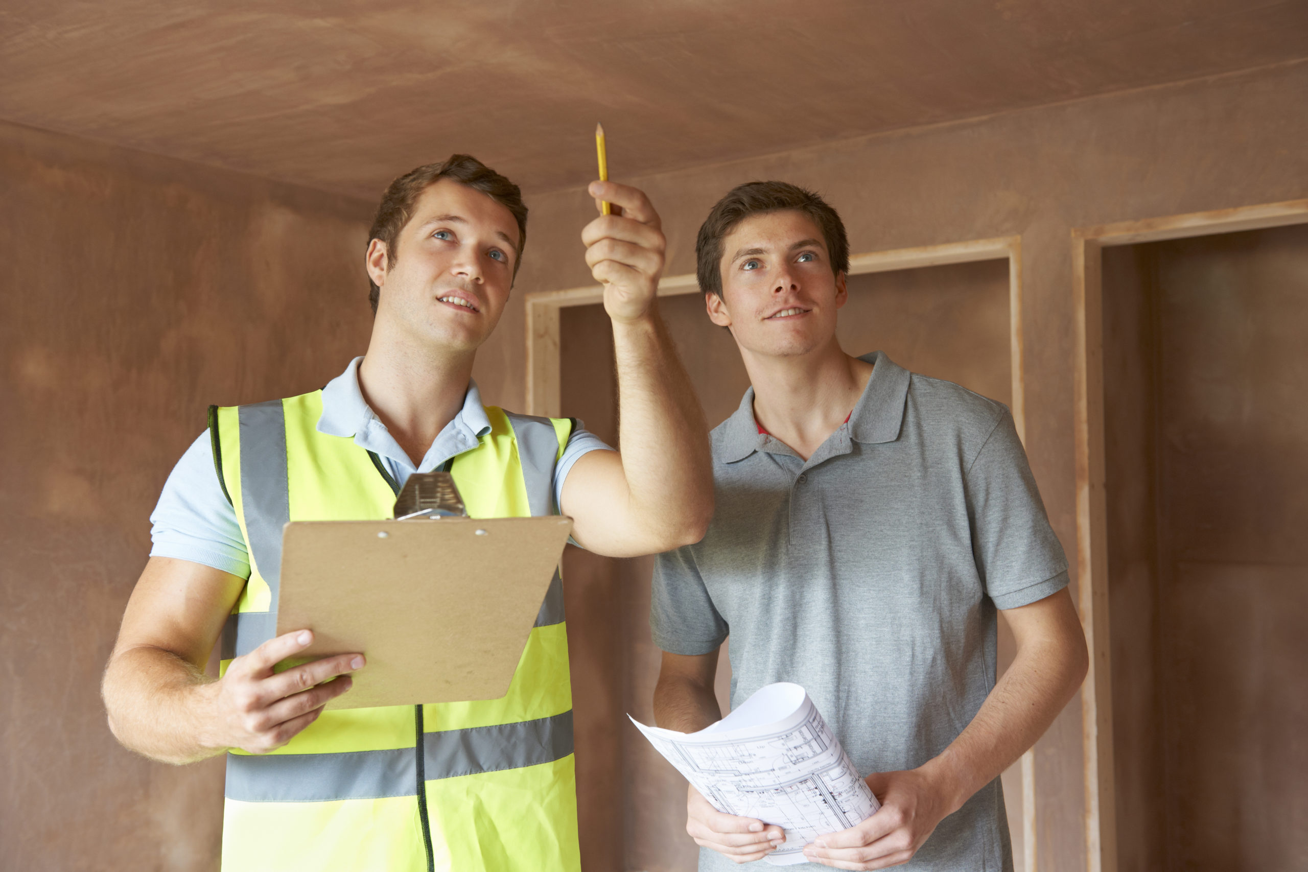 A couple of men standing next to each other and discussing about the roof construction