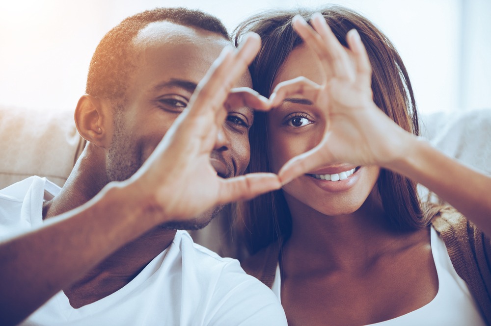 Couple holding a love sign with their hands